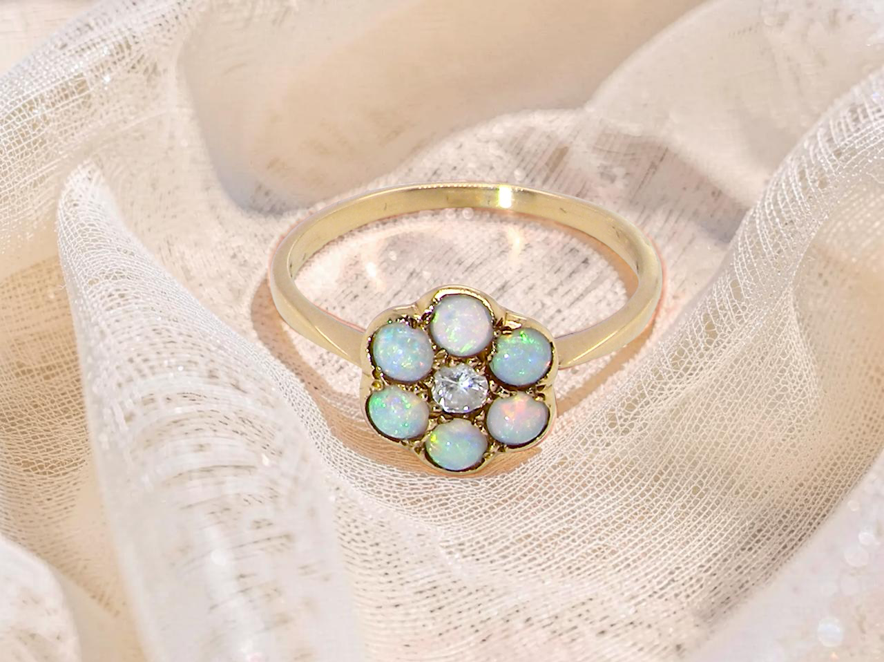 A daisy cluster dress ring. Set with a small diamond centre stone, (0.10 carats)