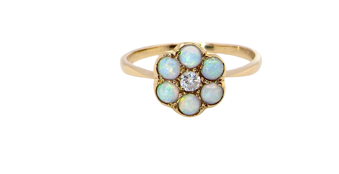 A daisy cluster dress ring. Set with a small diamond centre stone, diameter 3mm (0.10 carats)