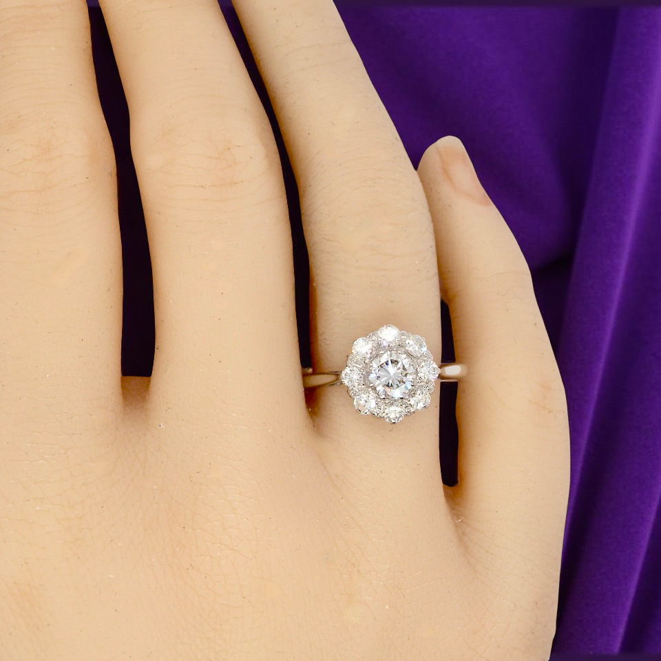 Diamond ring on a hand with a purple fabric background