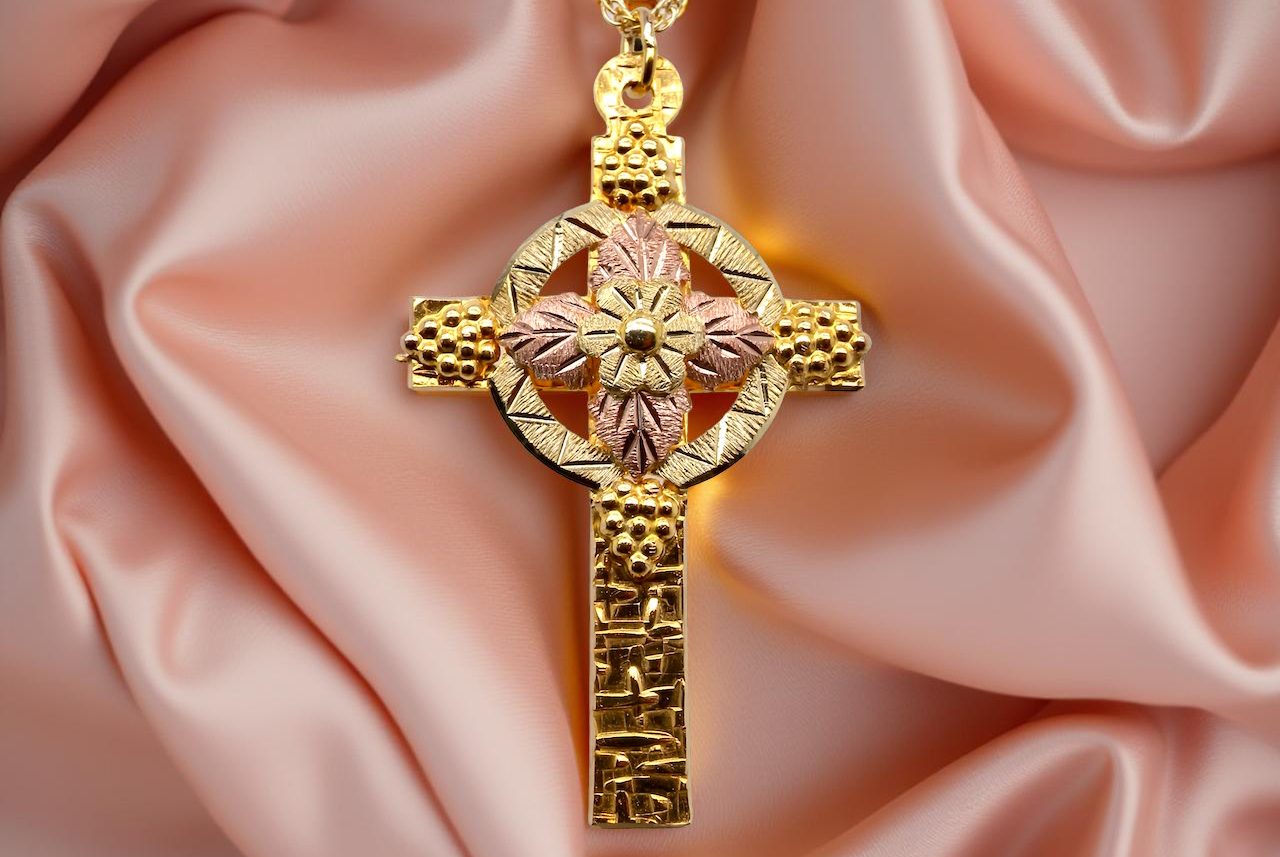 A fancy two colour gold cross and chain