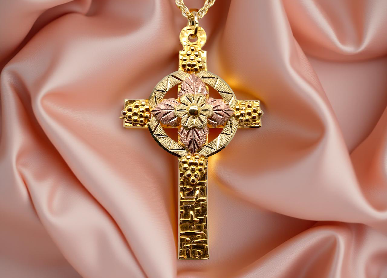 A fancy two colour gold cross and chain