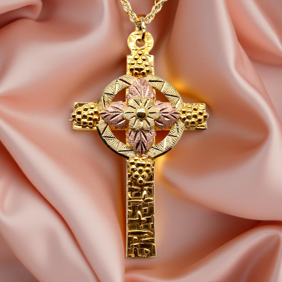 A fancy two colour gold cross and chain