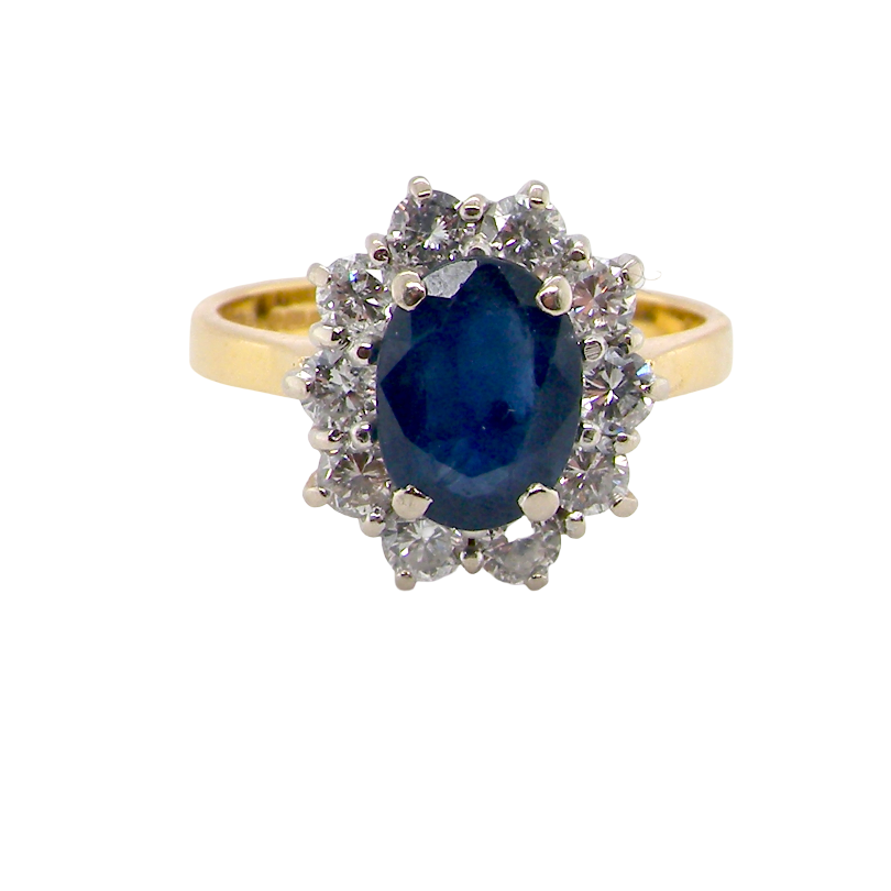 A yellow gold ring featuring an oval-cut deep blue sapphire center stone surrounded by a halo of small clear diamonds, set against a plain white background.