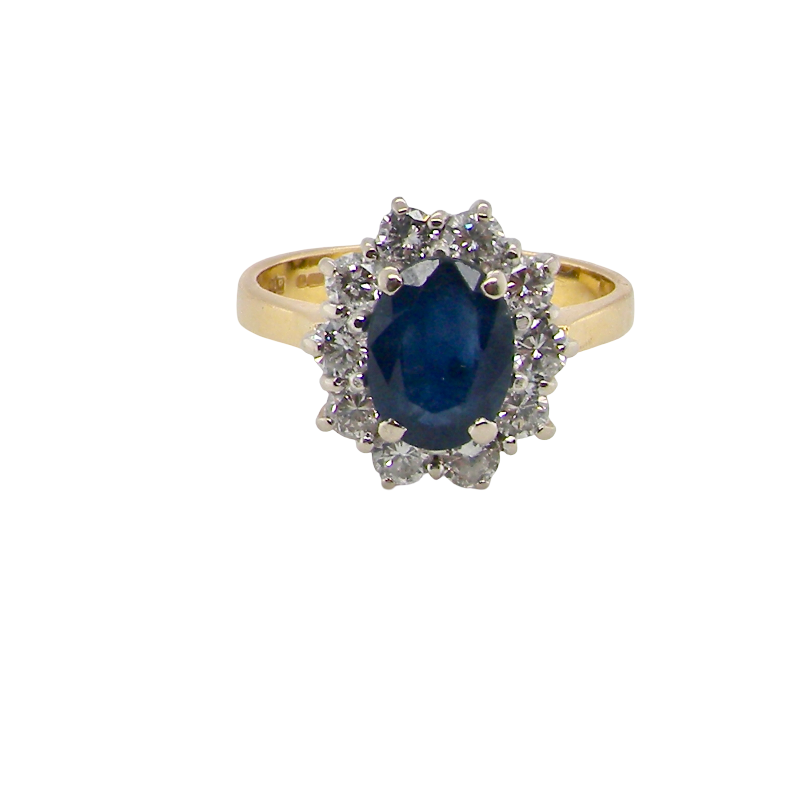 A yellow gold ring featuring an oval-cut dark blue sapphire center stone surrounded by a halo of small clear stones, set against a plain white background.
