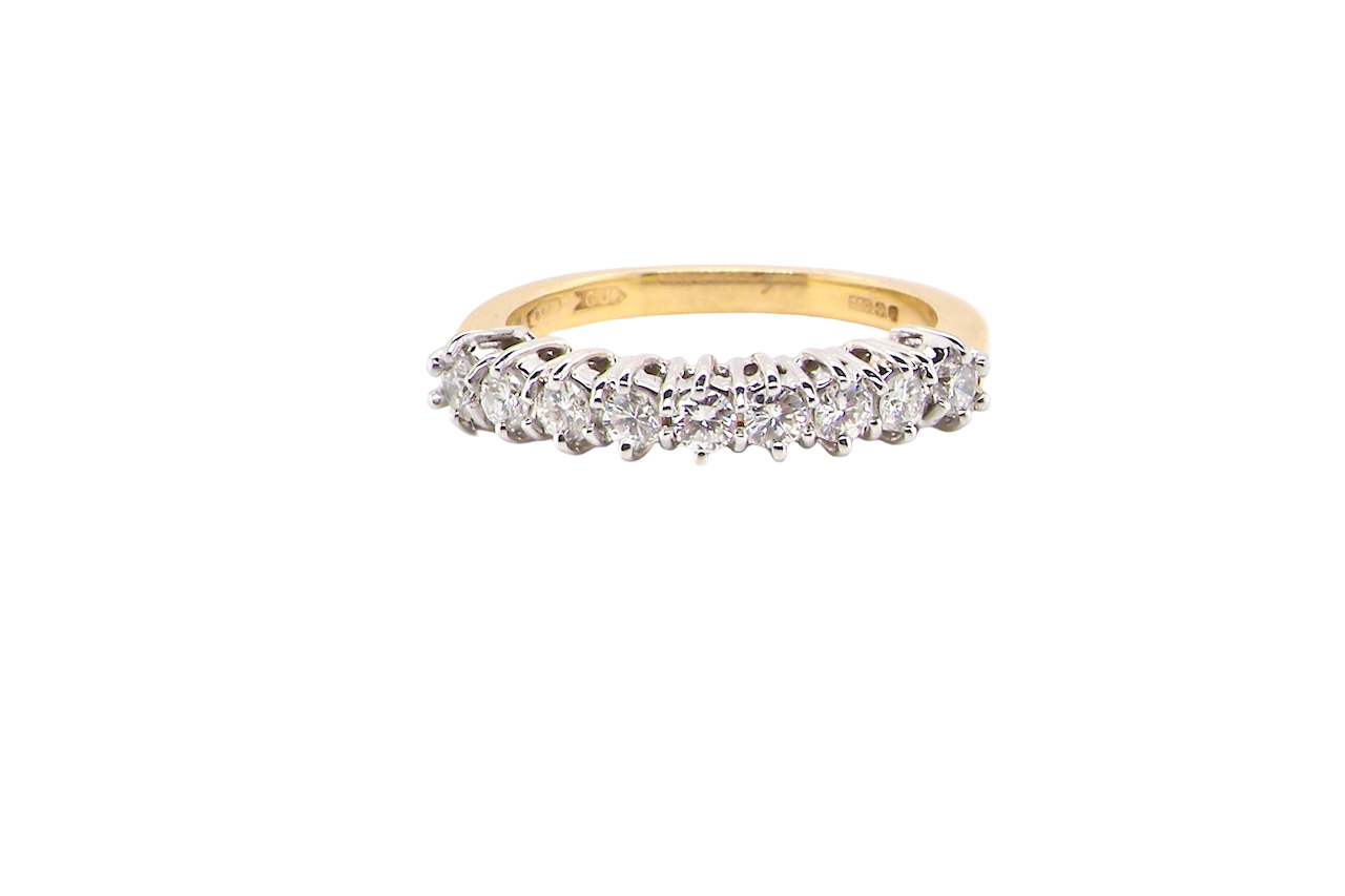 A fine 18 carat gold half hoop eternity ring, beautifully set with an array of seven brilliant-cut white diamonds.