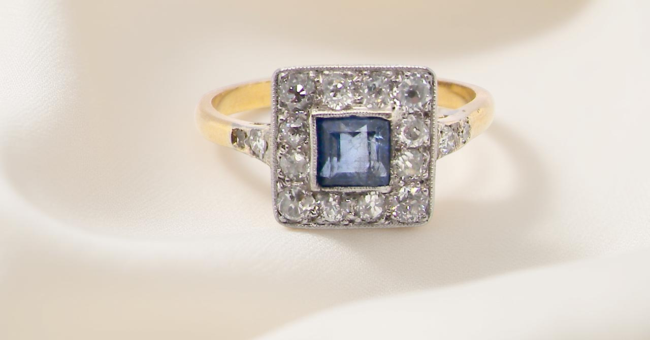 A fine Art Deco cluster ring. The centre stone a square sapphire 5x5mm (est 0.50 carats) mille grain setting.
