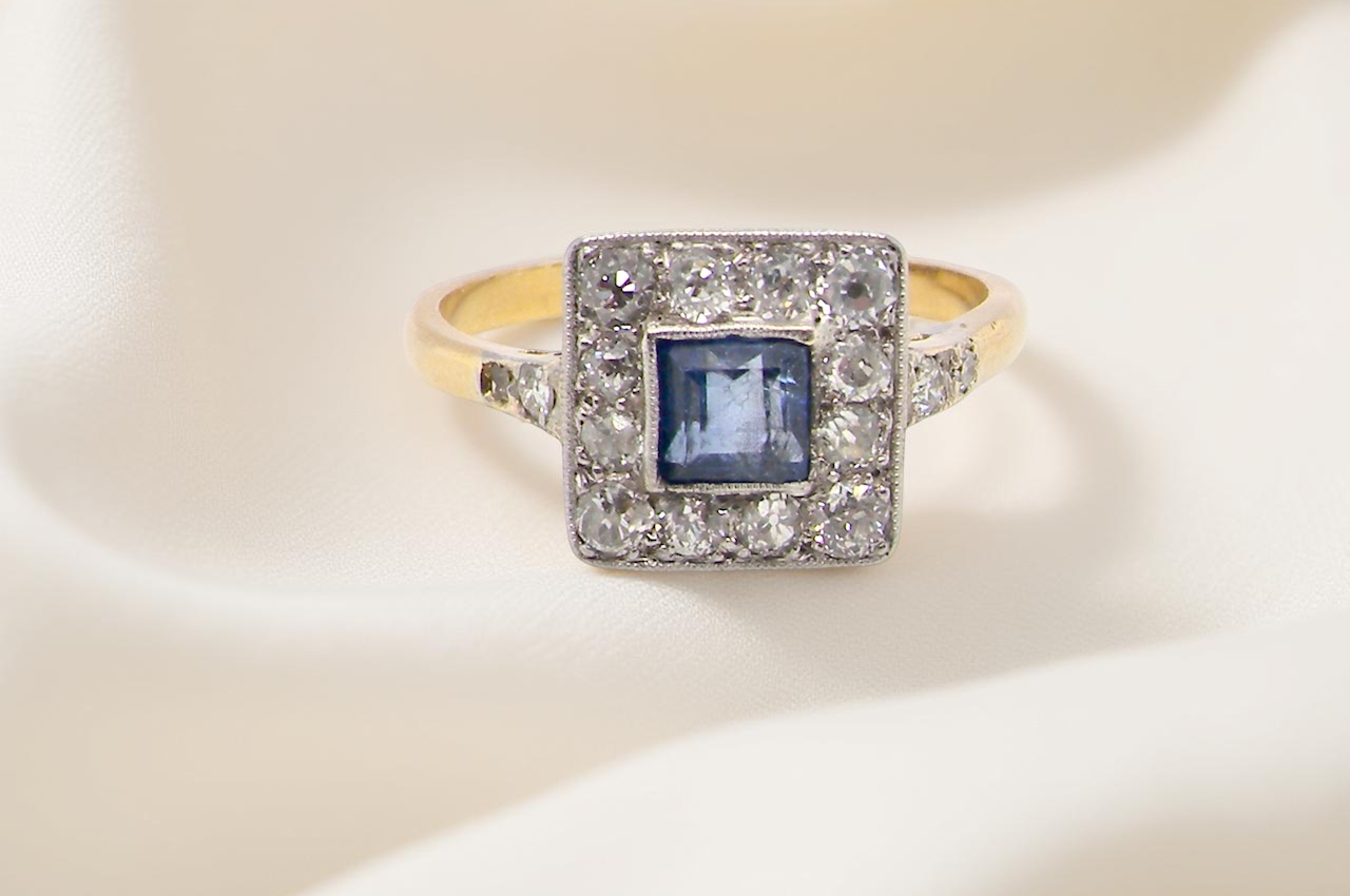 A fine Art Deco cluster ring. The centre stone a square sapphire 5x5mm (est 0.50 carats) mille grain setting.