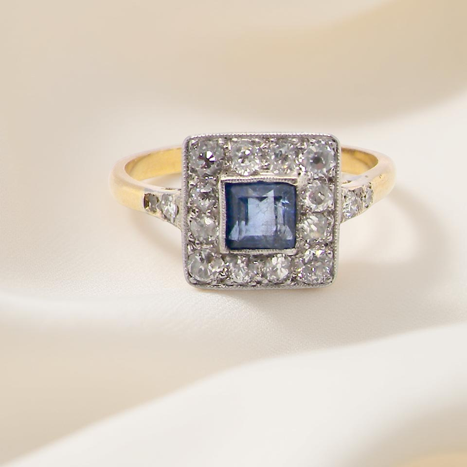 A fine Art Deco cluster ring. The centre stone a square sapphire 5x5mm (est 0.50 carats) mille grain setting.