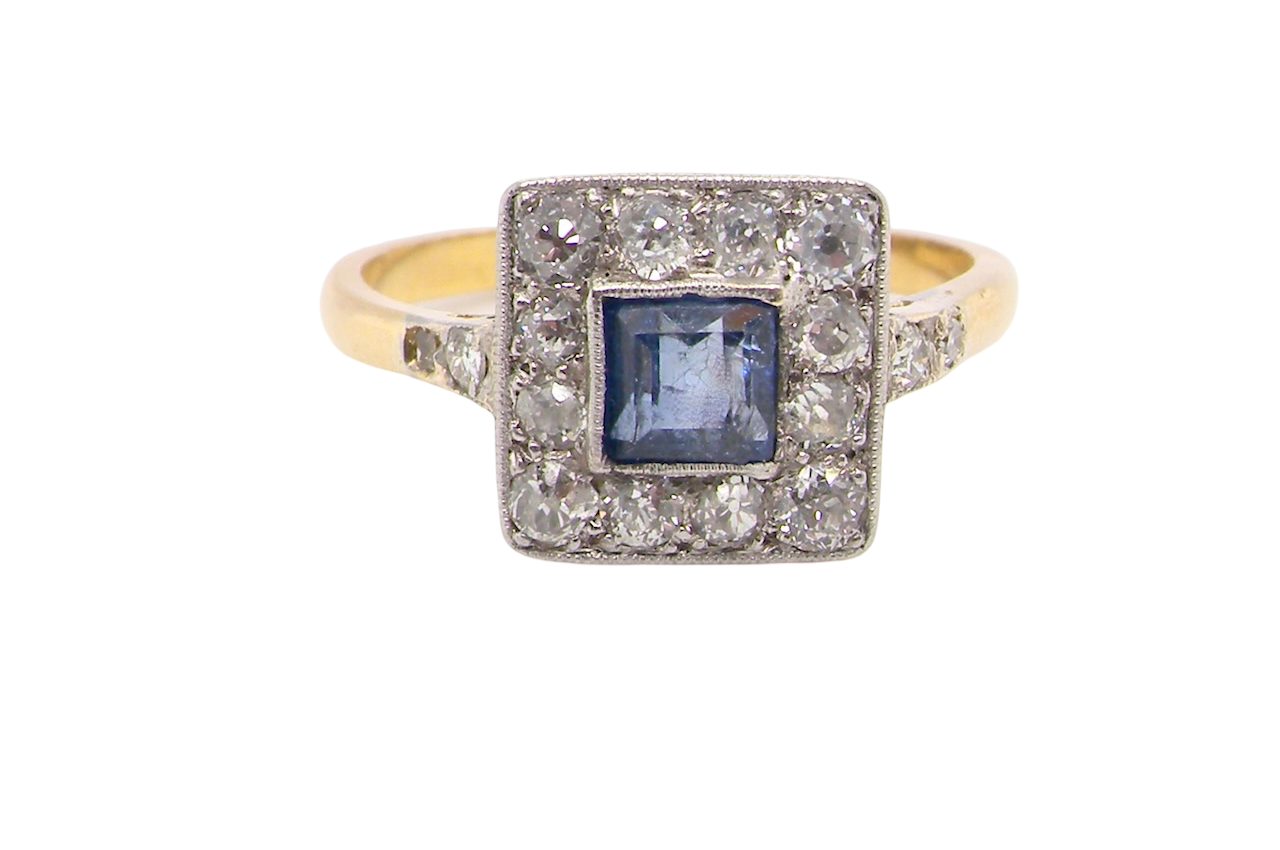 A fine Art Deco cluster ring. The centre stone a square sapphire 5x5mm in a mille grain setting.