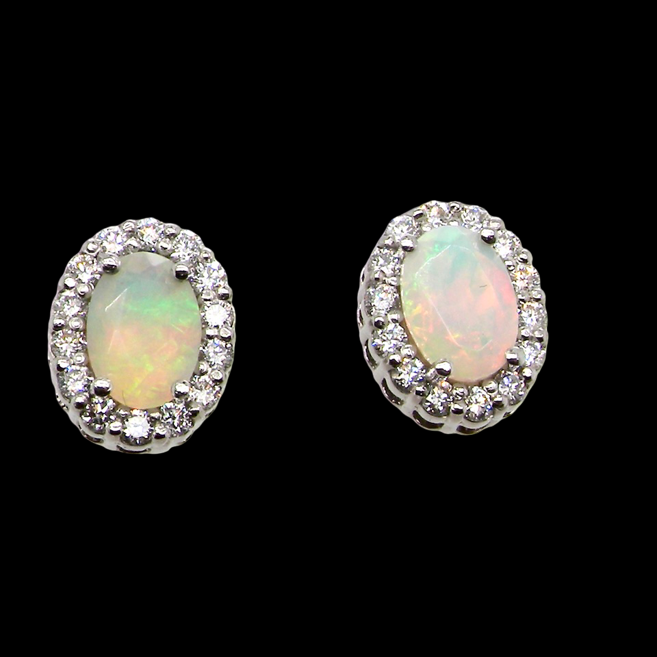 A fine and elegant pair of platinum* stud earrings, each beautifully set with an exceptional white opal