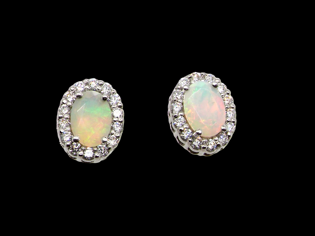 A fine and elegant pair of platinum* stud earrings, each beautifully set with an exceptional white opal