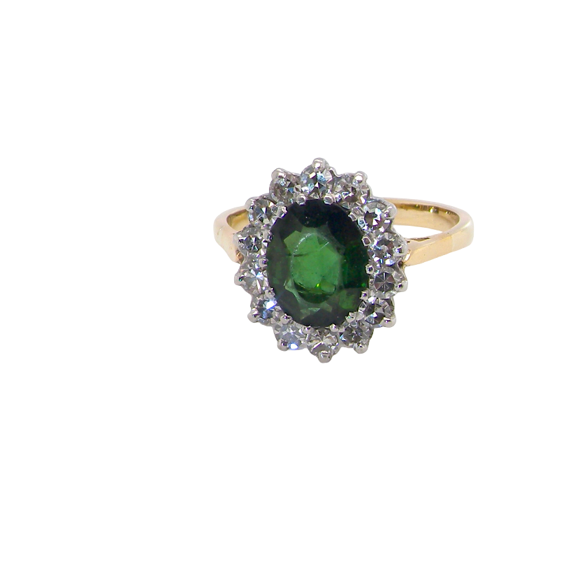 A fine and impressive vintage cluster ring, centred with a striking oval-cut deep dark green tourmaline, measuring 9 x 7mm and estimated to weigh approximately 2.00 carats.