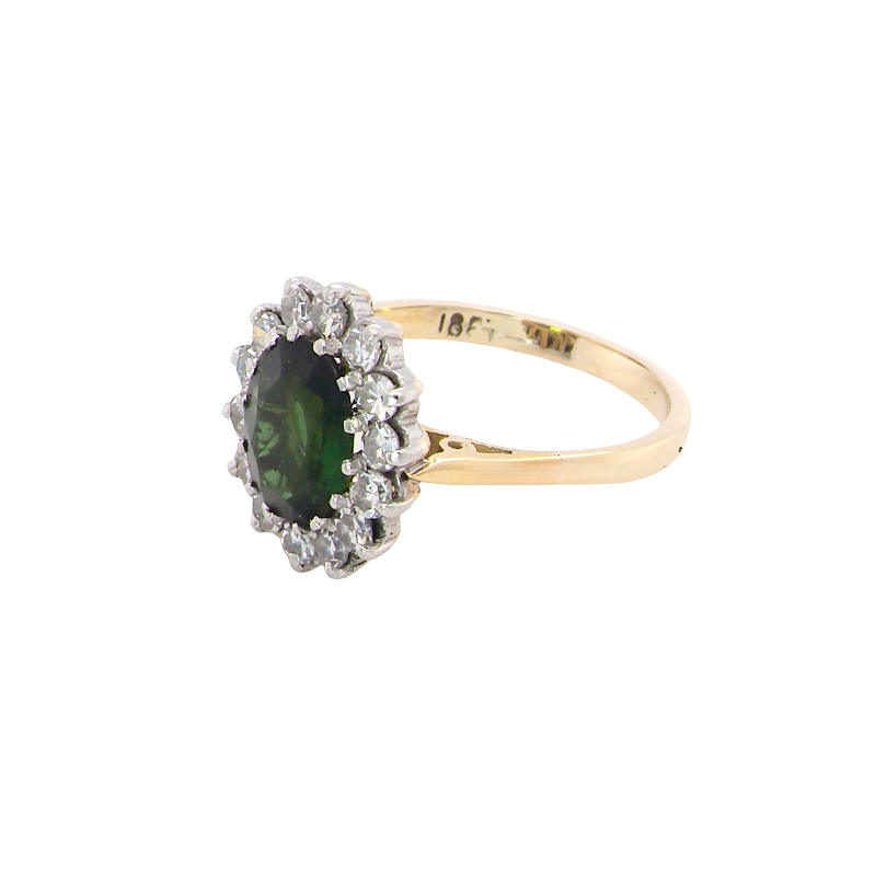 A fine and impressive vintage cluster ring, centred with a striking oval-cut deep dark green tourmaline, measuring 9 x 7mm and estimated to weigh approximately 2.00 carats. side