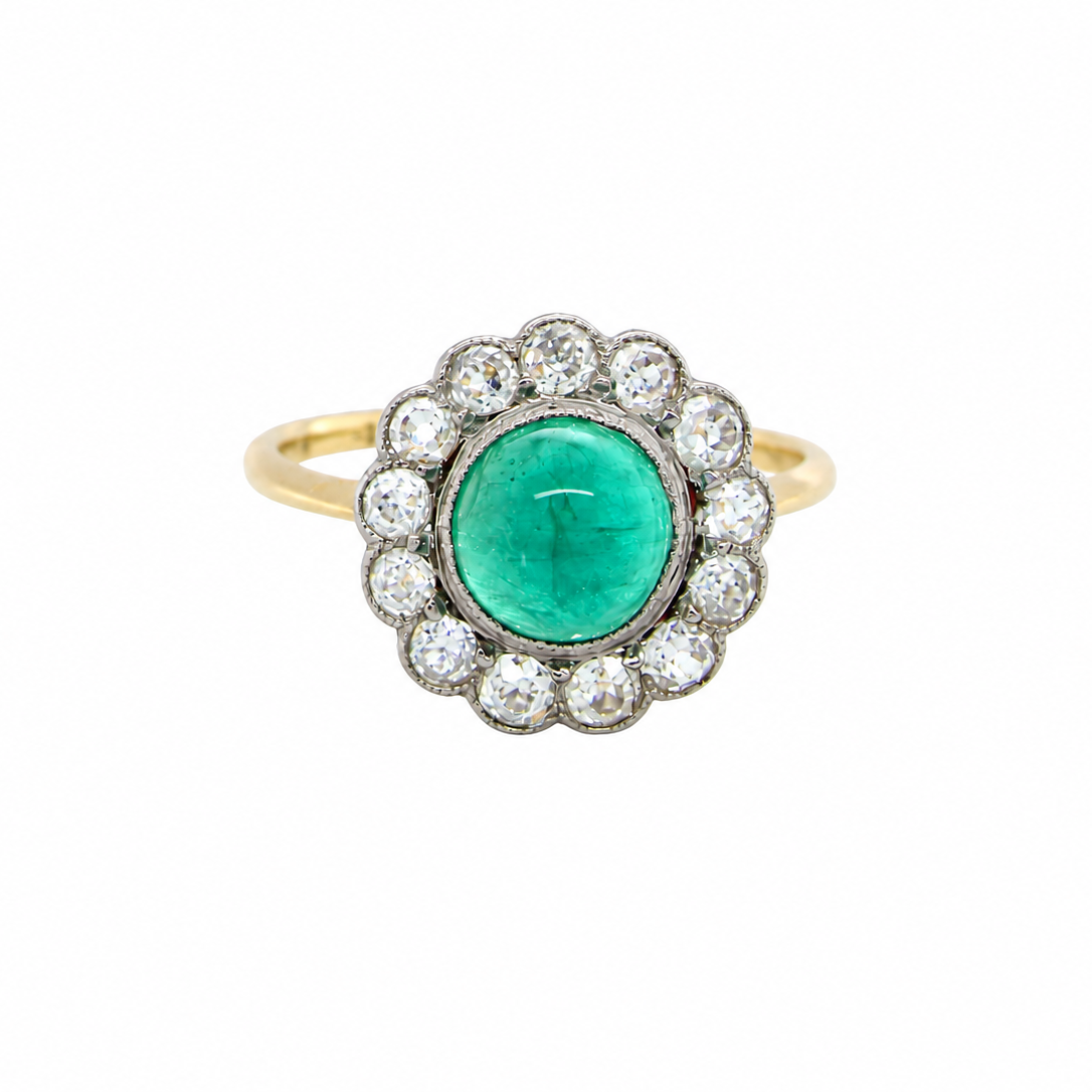 A fine antique cluster ring. The centre stone a cabouchon cut emerald