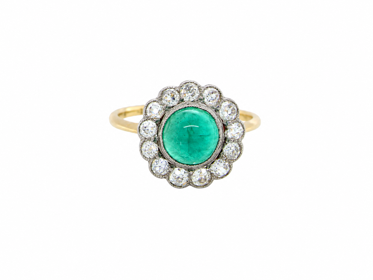 A fine antique cluster ring. The centre stone a cabouchon cut emerald