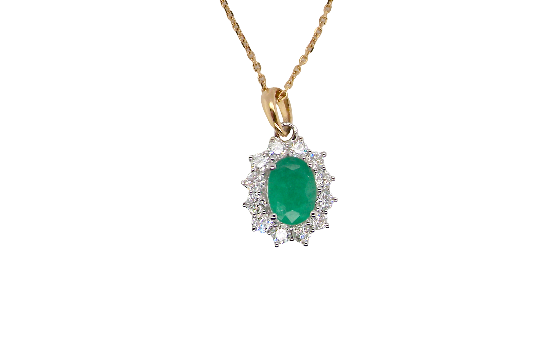 A fine cluster pendant. Features at the centre an oval cut emerald, measures 7.5x5mm (est one carat). Dark green hue, natural inclusions.