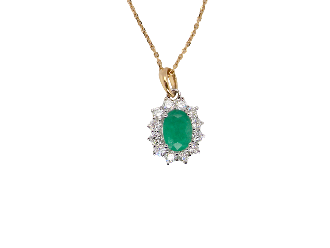 A fine cluster pendant. Features at the centre an oval cut emerald, measures 7.5x5mm (est one carat). Dark green hue, natural inclusions.