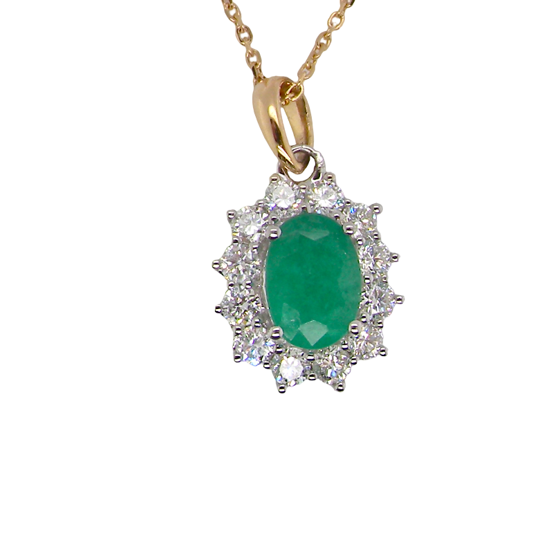 A fine cluster pendant. Features at the centre an oval cut emerald, measures 7.5x5mm (est one carat). natural inclusions.
