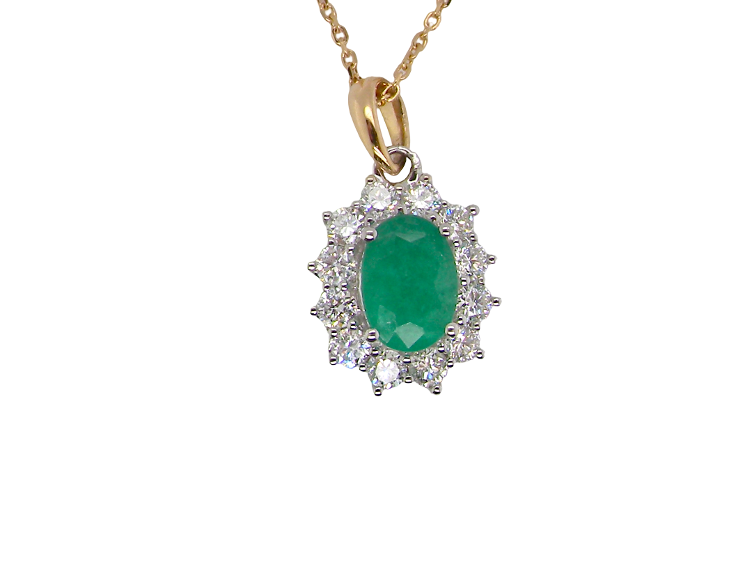 A fine cluster pendant. Features at the centre an oval cut emerald, measures 7.5x5mm (est one carat). natural inclusions.