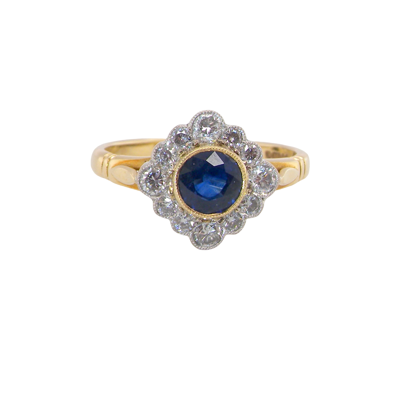 A fine cluster ring featuring to the centre a round dark blue sapphire, 5mm diameter (0.50 carats) mille grain setting.