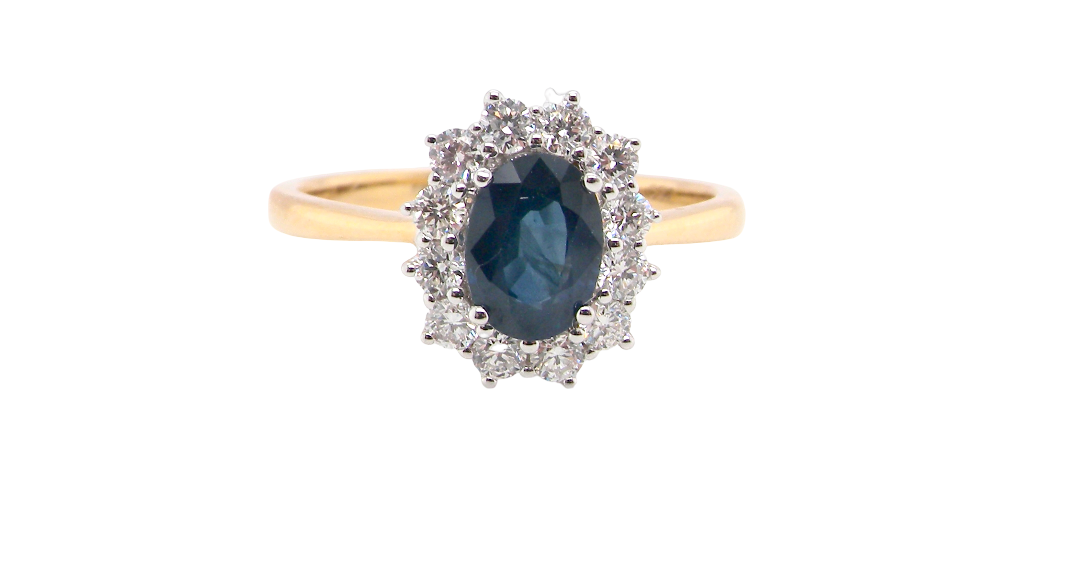 A fine cluster ring that features a black blue oval cut sapphire that measures 7x5mm