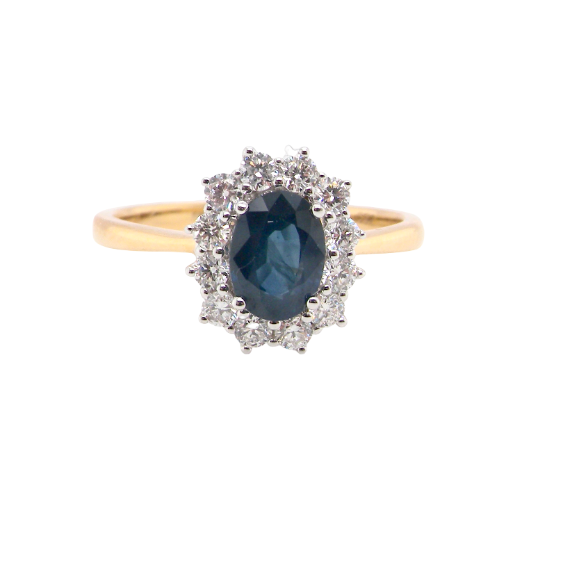 A fine cluster ring that features a black blue oval cut sapphire that measures 7x5mm