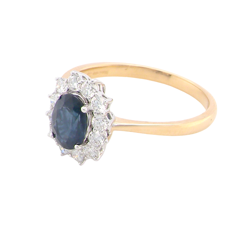 A fine cluster ring that features a black blue oval cut sapphire that measures 7x5mm (est 0.75 carats)
side