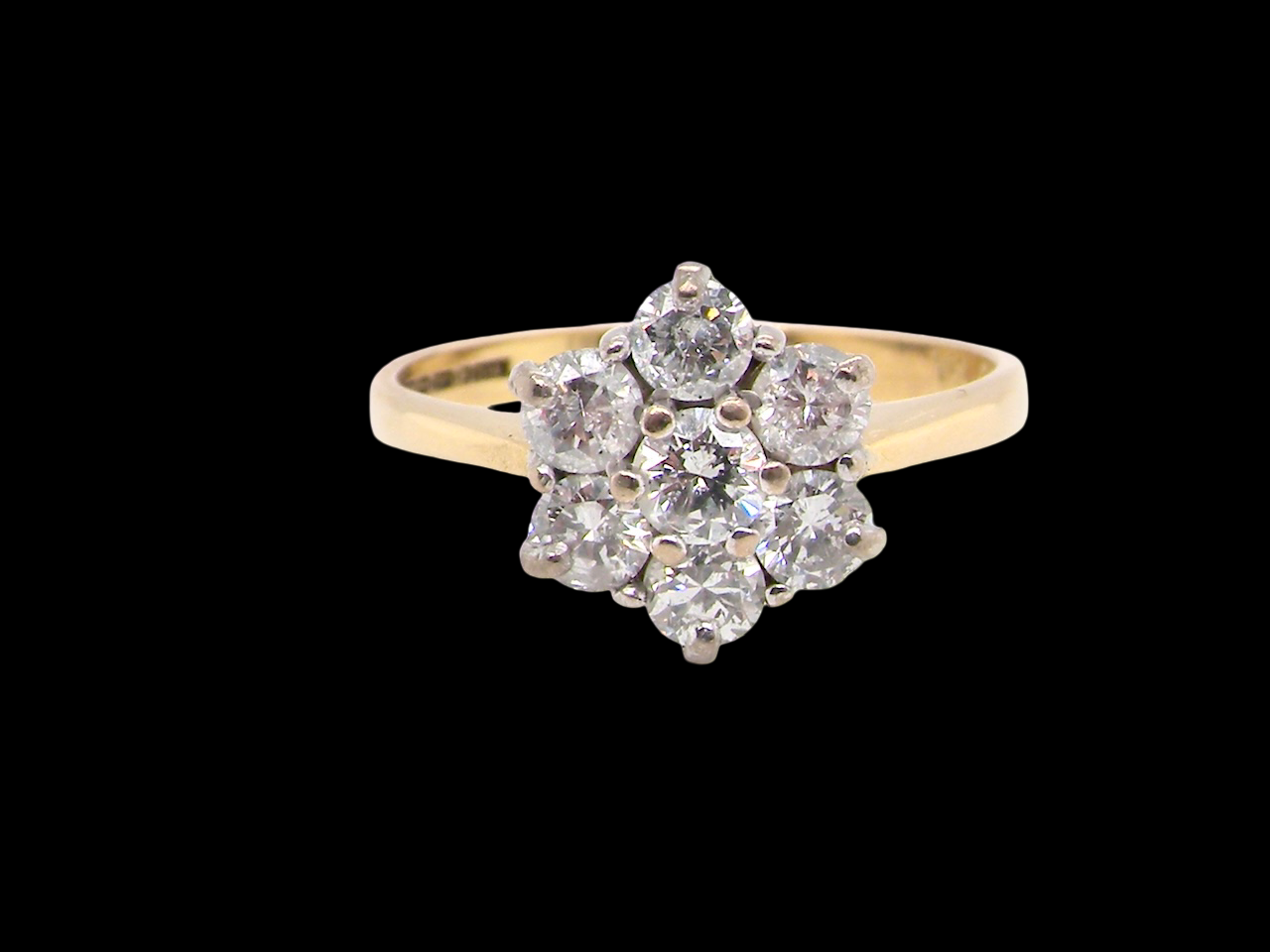 Diamond ring with a yellow gold band on a black background
