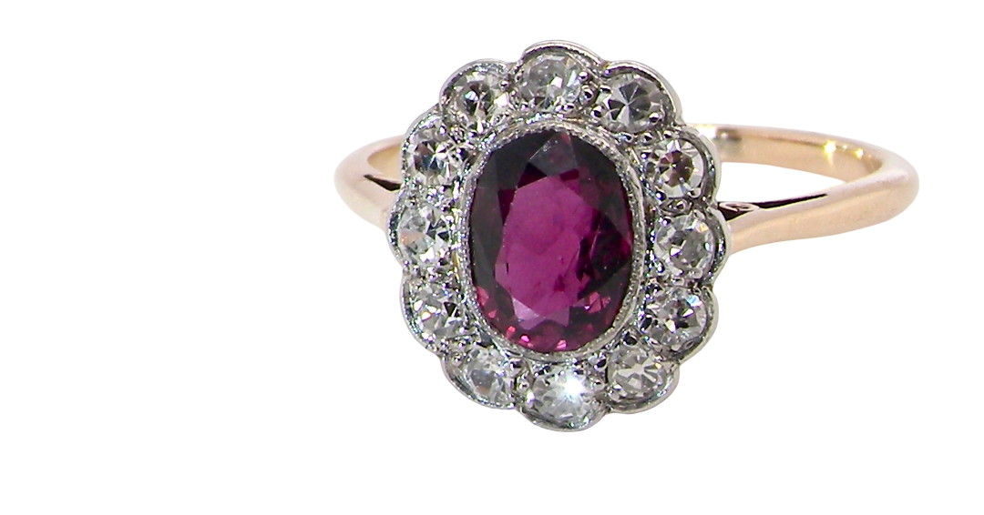 A fine early 20th century cluster ring featuring to the centre an oval ruby, 6x5mm, deep burgundy red colour, (est 1.02 carats)
