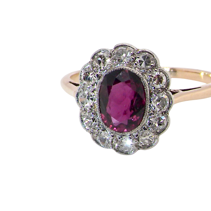 A fine early 20th century cluster ring featuring to the centre an oval ruby, 6x5mm, deep burgundy red colour, (est 1.02 carats)