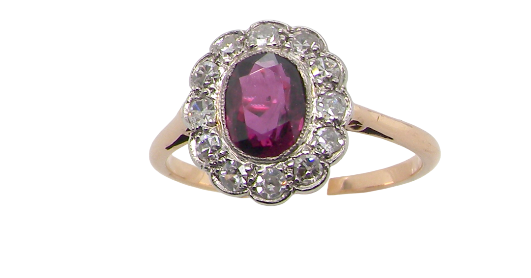 A fine early 20th century cluster ring featuring to the centre an oval ruby, 6x5mm, deep burgundy red colour, mille grain setting.