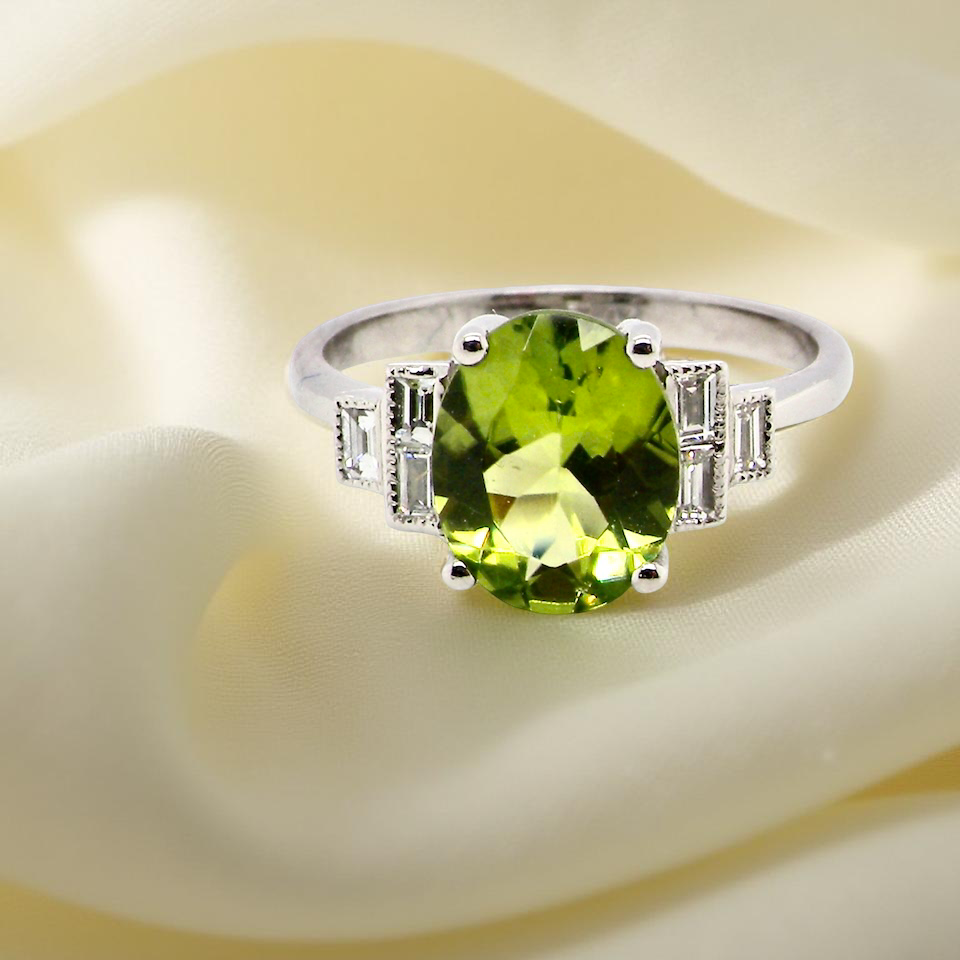 A fine gem set ring featuring a lime-green oval faceted peridot,