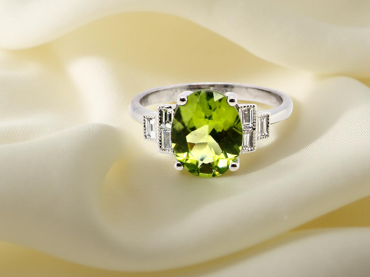 A fine gem set ring featuring a lime-green oval faceted peridot,