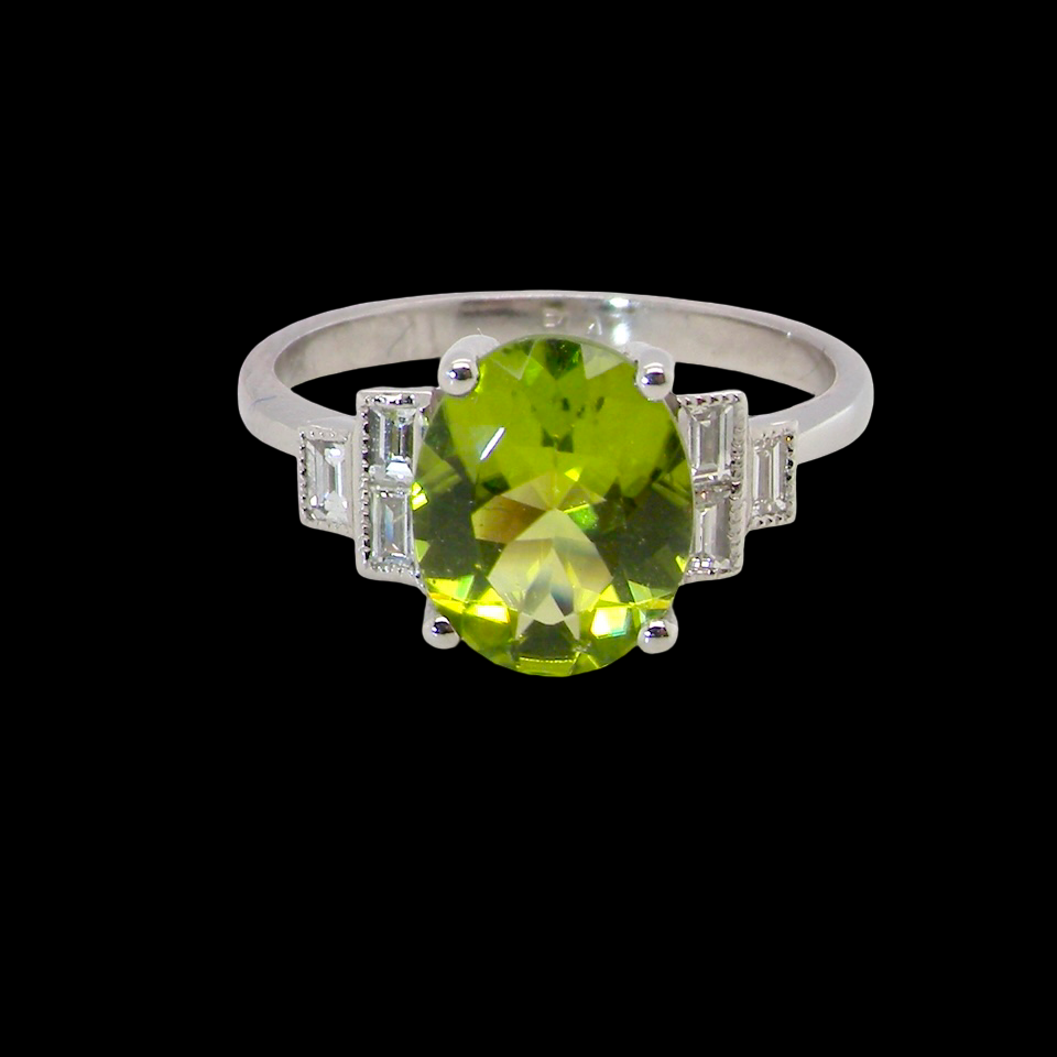 A fine gem set ring featuring an oval faceted peridot,