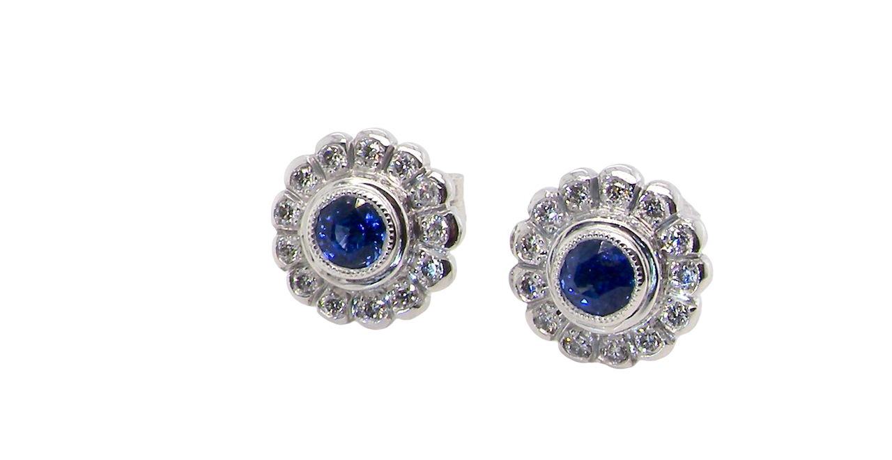 A fine pair of 18 carat white gold sapphire and diamond cluster earrings.
Each earring is set with a central round sapphire measuring approximately 3.4mm in diameter, estimated at 0.15ct,