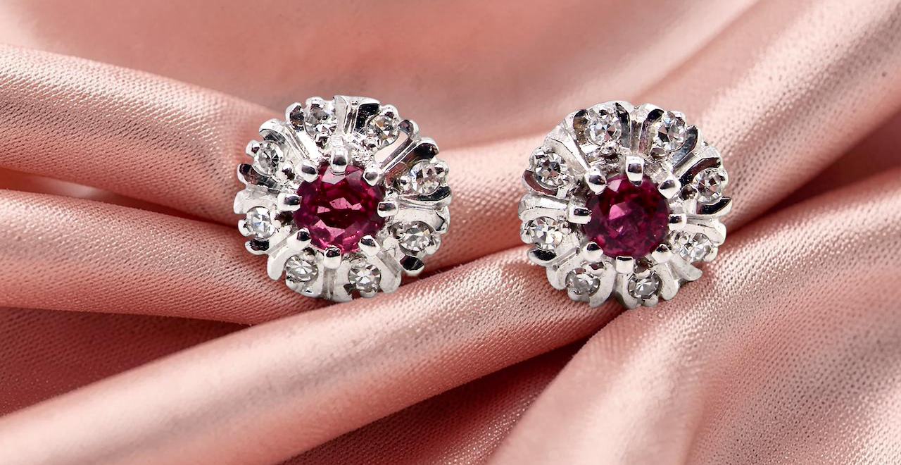A fine pair of cluster earrings. Features to the centre a round 4.6mm pink sapphire with a good deep colour hue.