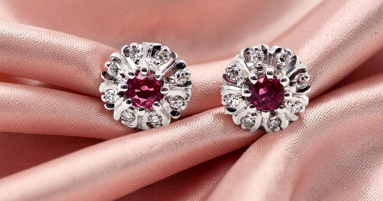 A fine pair of cluster earrings. Features to the centre a round 4.6mm pink sapphire with a good deep colour hue.