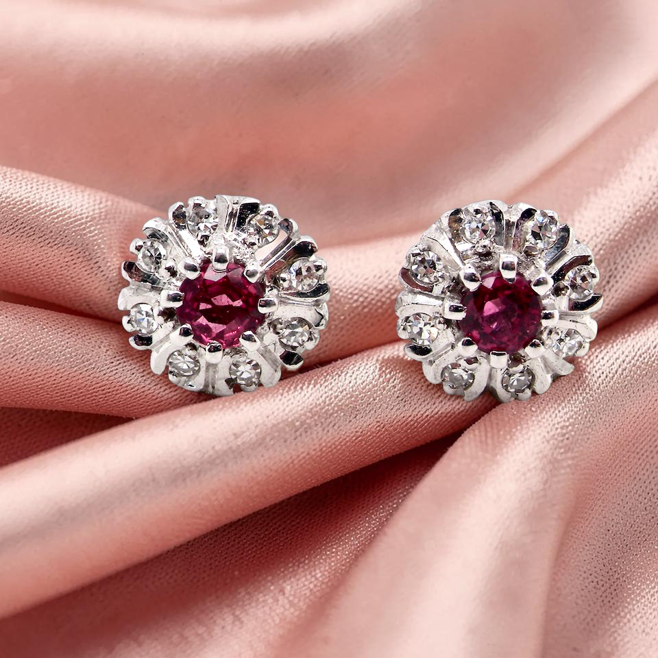 A fine pair of cluster earrings. Features to the centre a round 4.6mm pink sapphire with a good deep colour hue.