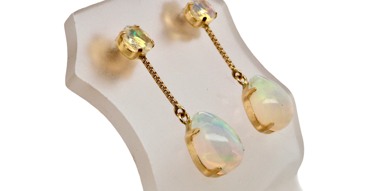 A fine pair of drop earrings. Suspending from a round opal which is at the head of the post, (measures 4mm) a pear shaped opal 8x6mm,