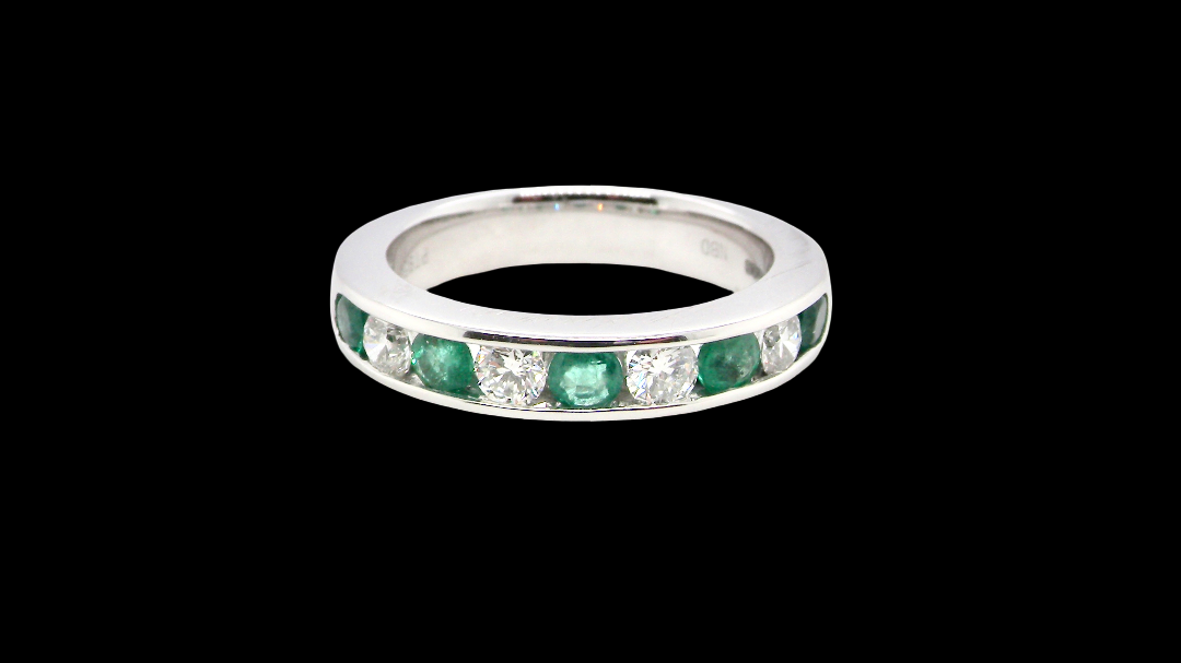 A fine platinum half hoop eternity ring. This is a new ring*. Channel set gem stones, five bright green emeralds 2.6mm each
