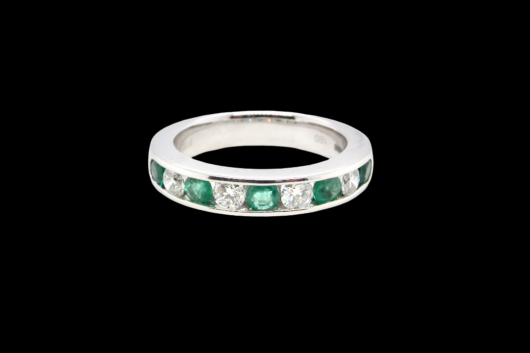 A fine platinum half hoop eternity ring. This is a new ring*. Channel set gem stones, five bright green emeralds 2.6mm each