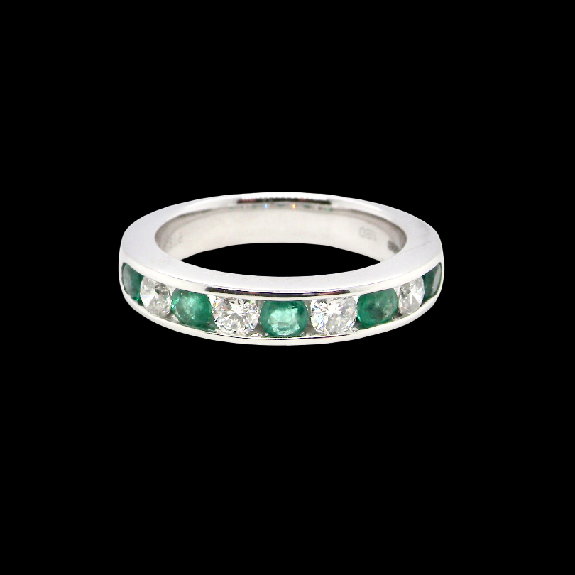 A fine platinum half hoop eternity ring. This is a new ring*. Channel set gem stones, five bright green emeralds 2.6mm each