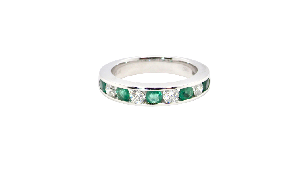 A fine platinum half hoop eternity ring. This is a new ring*. Channel set gem stones, five bright green emeralds 2.6mm each (0.54 carats total)