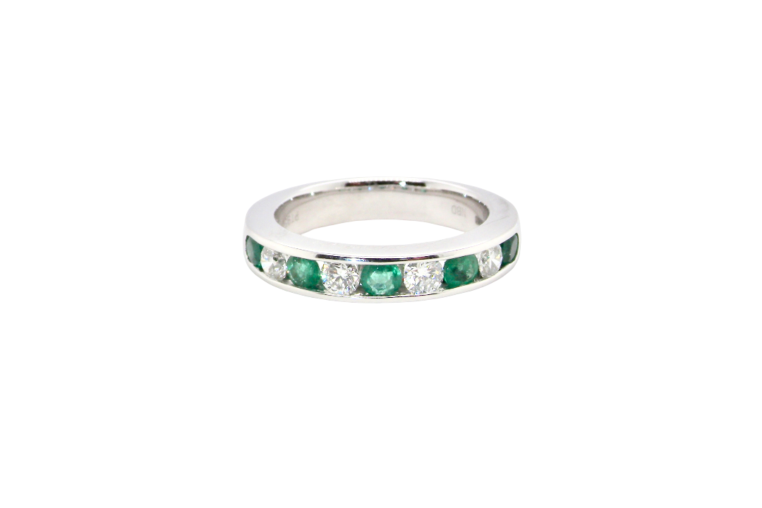 A fine platinum half hoop eternity ring. This is a new ring*. Channel set gem stones, five bright green emeralds 2.6mm each (0.54 carats total)