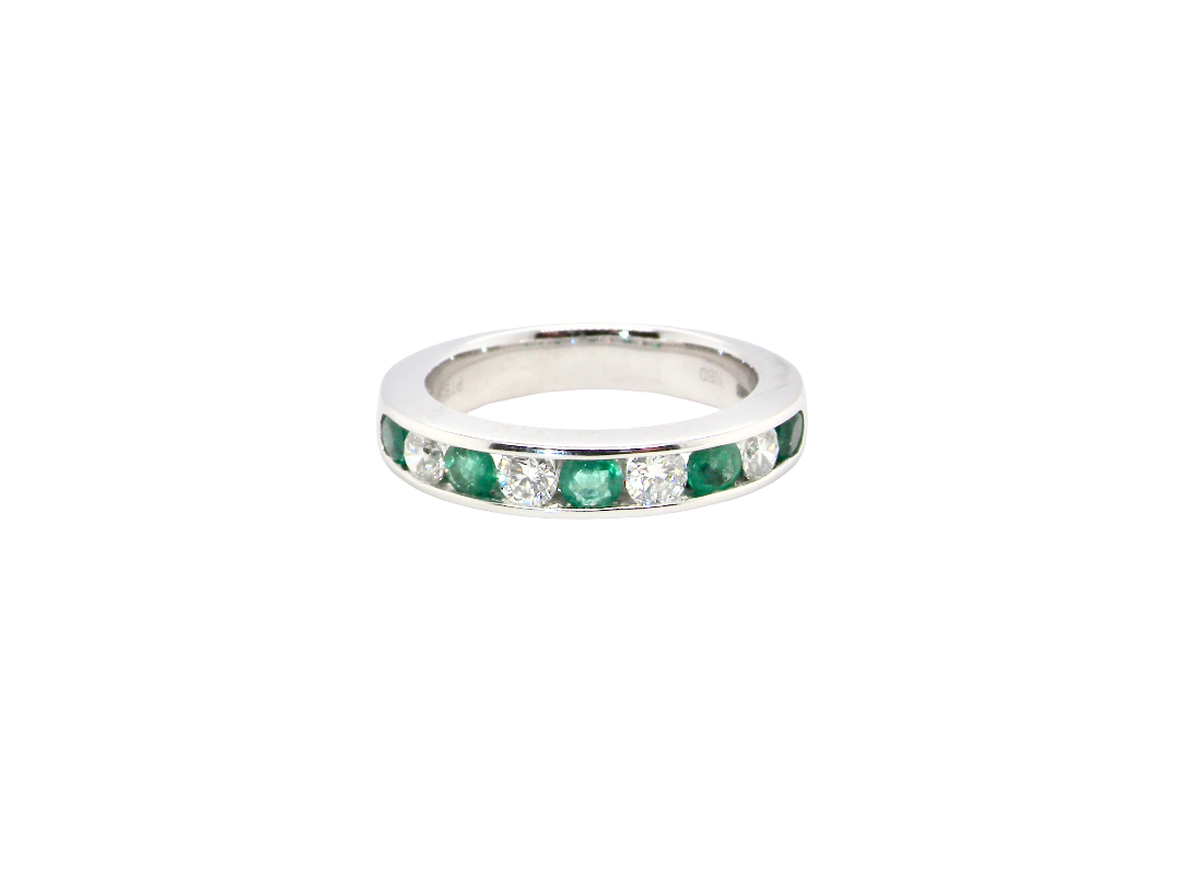 A fine platinum half hoop eternity ring. This is a new ring*. Channel set gem stones, five bright green emeralds 2.6mm each (0.54 carats total)
