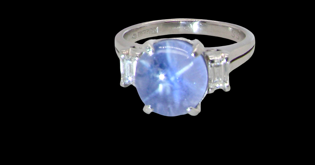 A fine platinum* ring. Features a lovely sky blue sapphire with 'star sapphire ' chatoyancy , measures 10x9mm, (est 4 carats) cabouchon cut