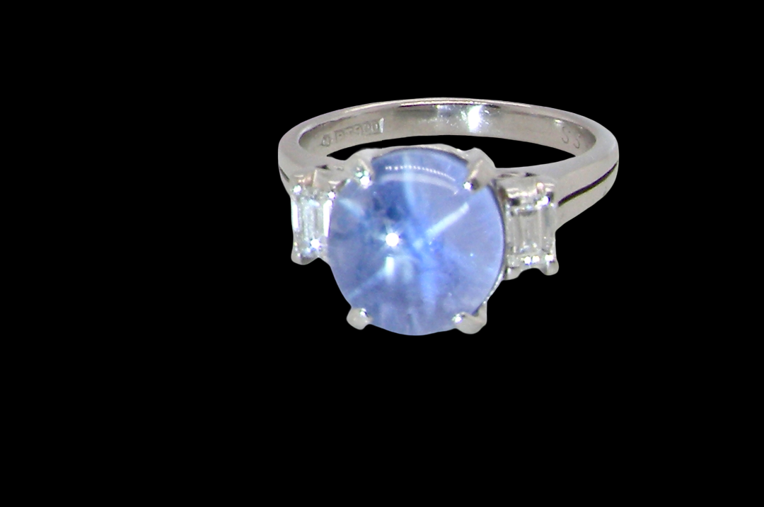 A fine platinum* ring. Features a lovely sky blue sapphire with 'star sapphire ' chatoyancy , measures 10x9mm, (est 4 carats) cabouchon cut