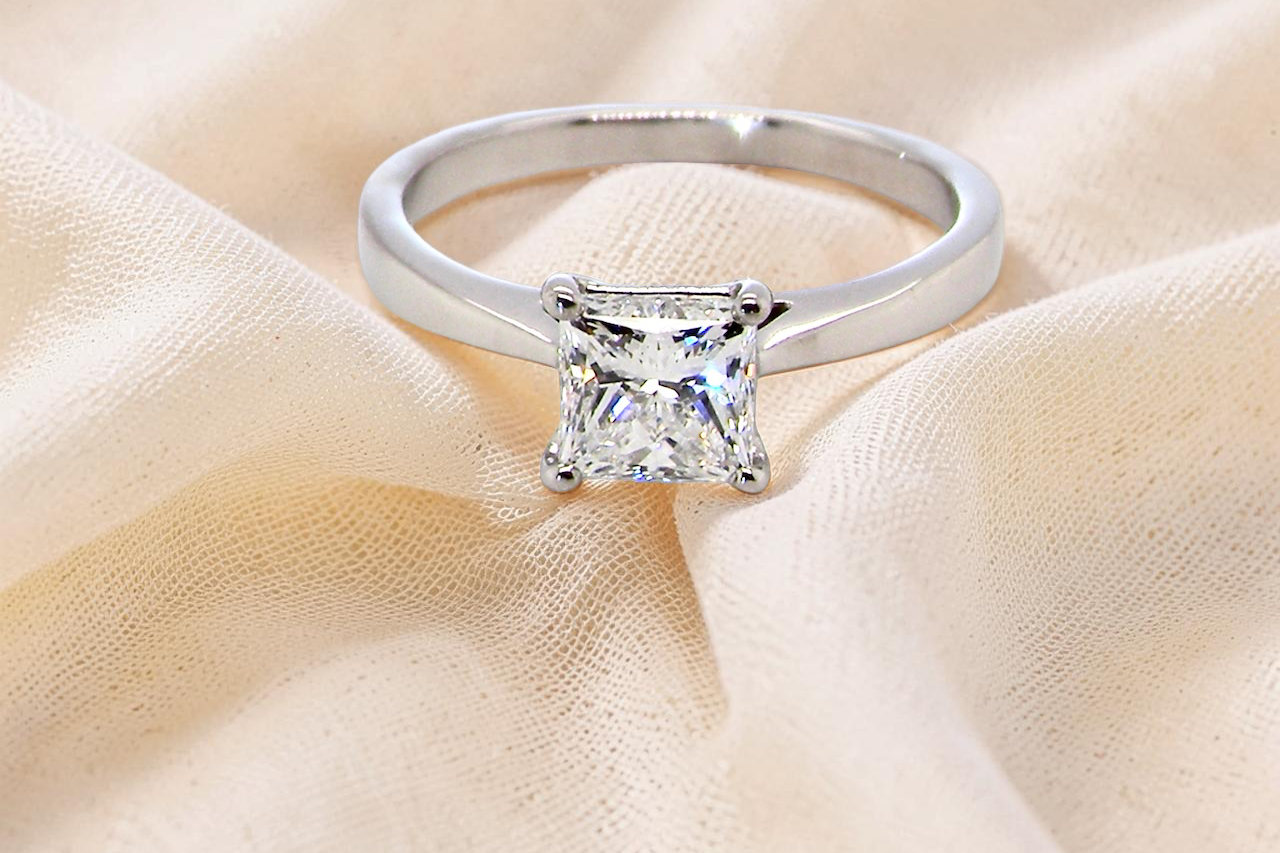 A fine solitaire ring featuring a square cut diamond of excellent quality.
Superb colour grade of E, excellent clarity- graded VVS2*. confirmed as 0.83 carats.
