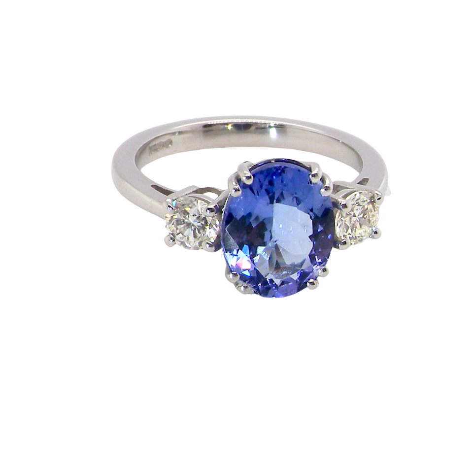 A fine three stone trilogy ring. The centre stone a 4A tanzanite gem stone, measures 10x8mm 