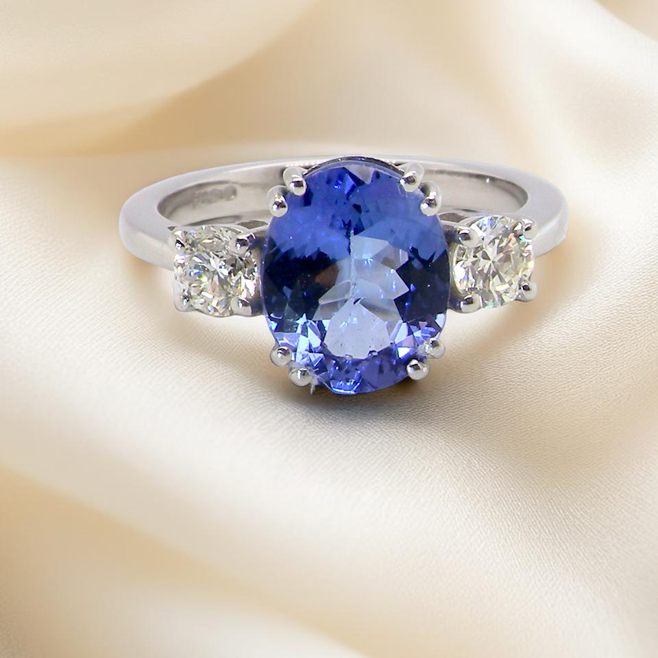 A fine three stone trilogy ring. The centre stone a tanzanite gem stone, measures 10x8mm (est 3 carats) 